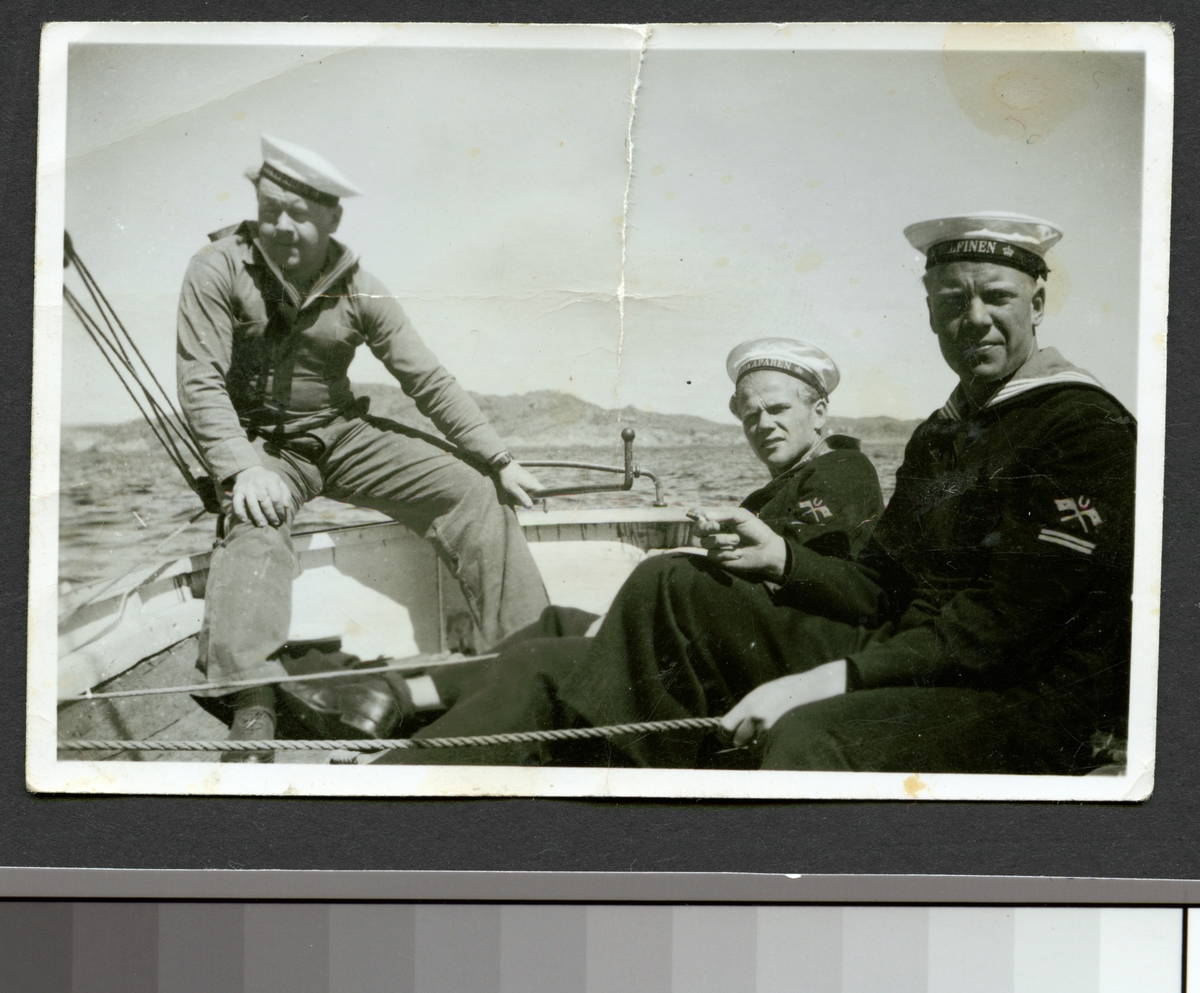 Bilden visar tre ubåtsmän från olika ubåtar som seglar i en skeppsbåt.