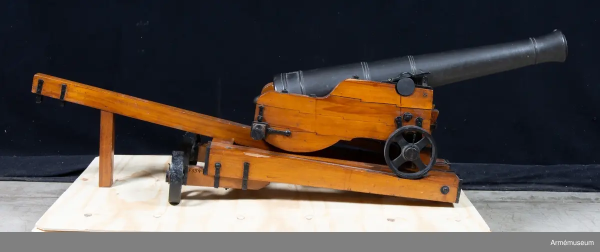 Grupp F I. 
Skala 1/4.
Kapten F A Spaks katalog 1888.  
Till modellen hör även släpa, 24-pundig kanon (modellen av trä).
Modelletikett med text: "Modell på en 24-pundig kanon med Lavett. Canon efter 1785 års ritning. Lavetten efter General Fält Tygmästaren, Chefen för K. Maj:ts artillerie m m välborne Herr C. Helvigs invention. 1/4 utaf rätta Storleken gjord i Stockholm år 1808 af G. W. Stehlenert, artillerie Byggmästare."
