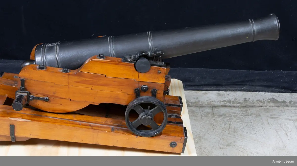 Grupp F I. 
Skala 1/4.
Kapten F A Spaks katalog 1888.  
Till modellen hör även släpa, 24-pundig kanon (modellen av trä).
Modelletikett med text: "Modell på en 24-pundig kanon med Lavett. Canon efter 1785 års ritning. Lavetten efter General Fält Tygmästaren, Chefen för K. Maj:ts artillerie m m välborne Herr C. Helvigs invention. 1/4 utaf rätta Storleken gjord i Stockholm år 1808 af G. W. Stehlenert, artillerie Byggmästare."