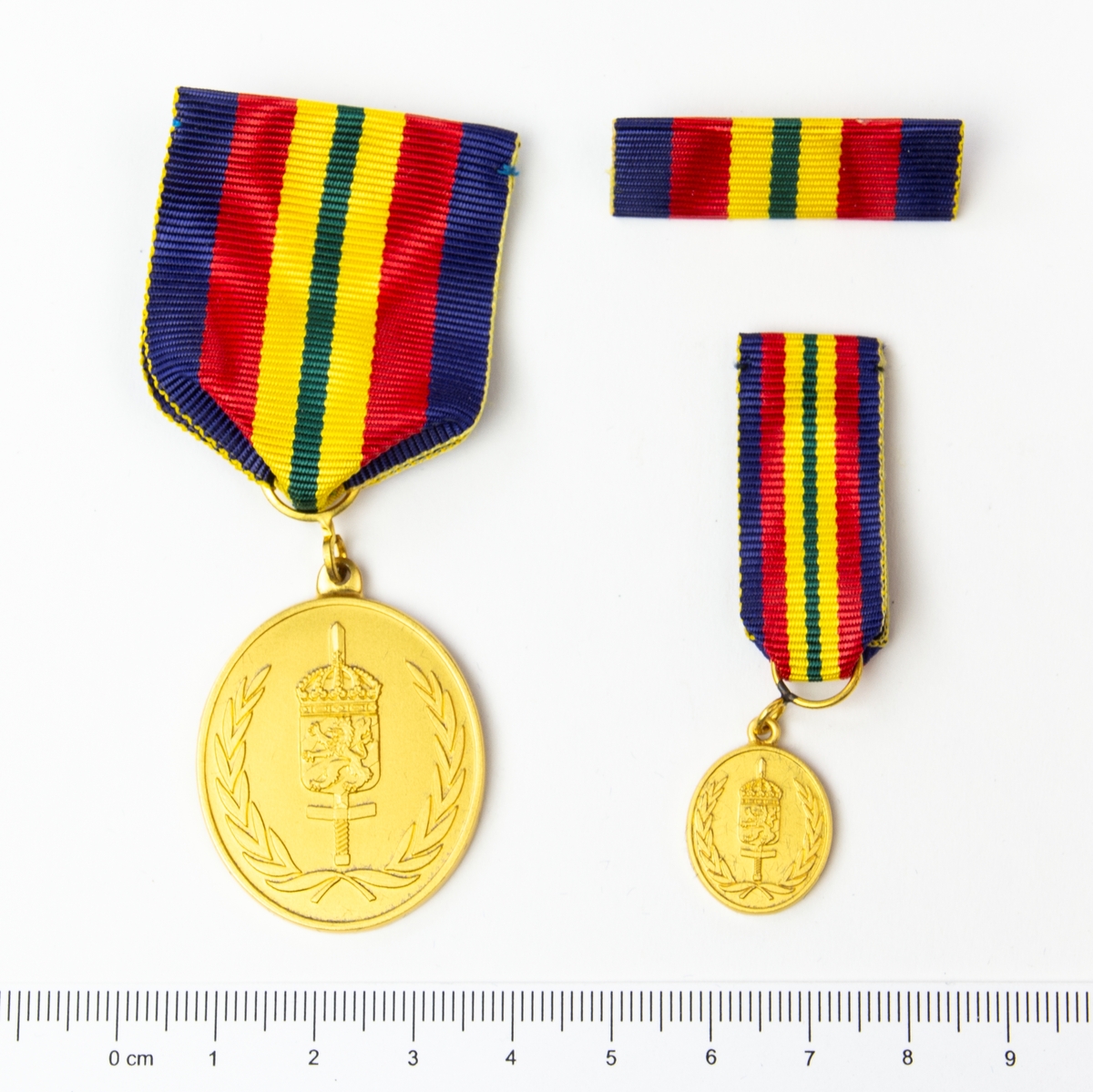 2 st medaljer och 1 st utmärkelsetecken. Framsida med lagerkrans, svärd och heraldiskt vapen. Förvaras i originalask.