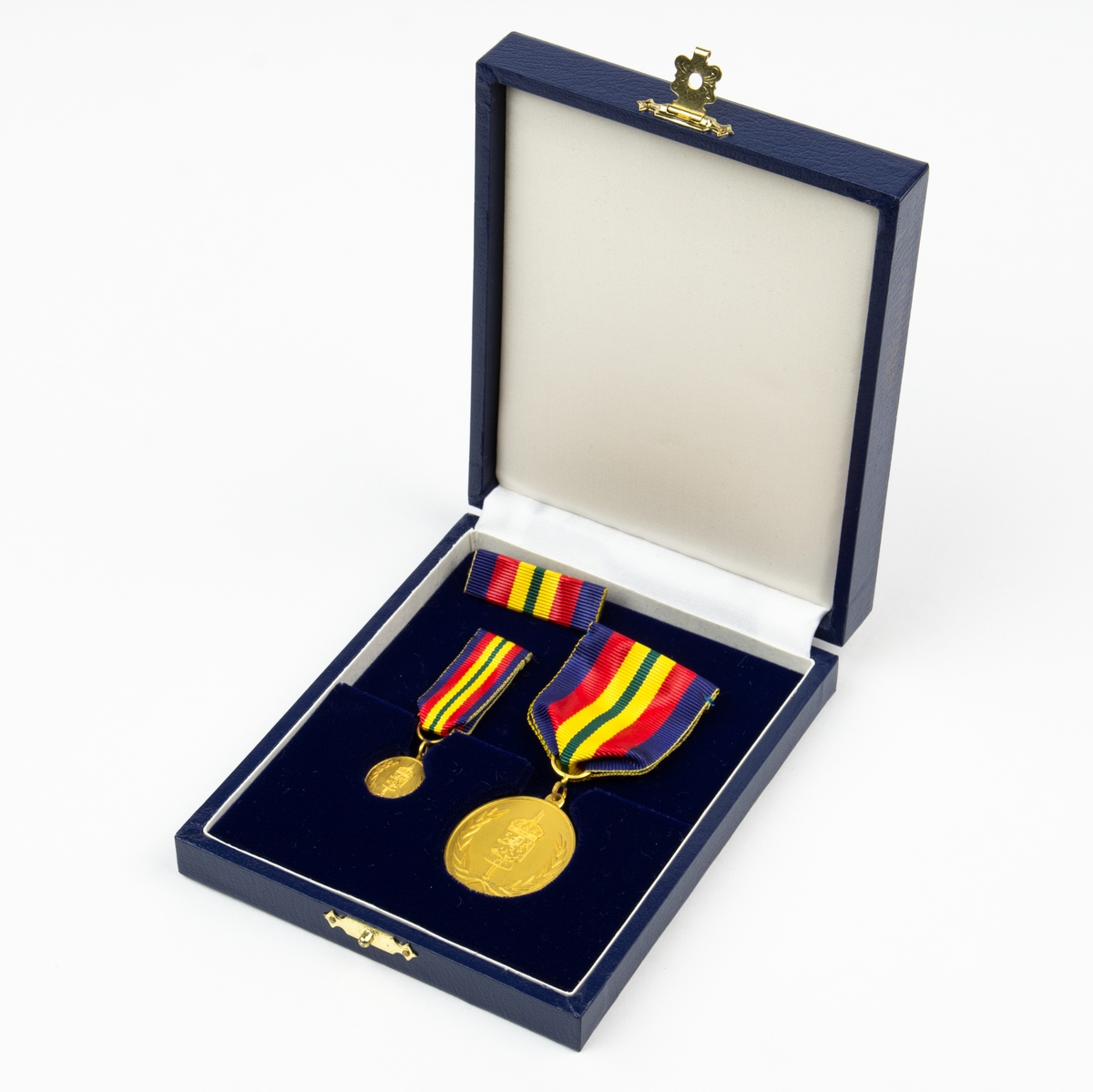 2 st medaljer och 1 st utmärkelsetecken. Framsida med lagerkrans, svärd och heraldiskt vapen. Förvaras i originalask.
