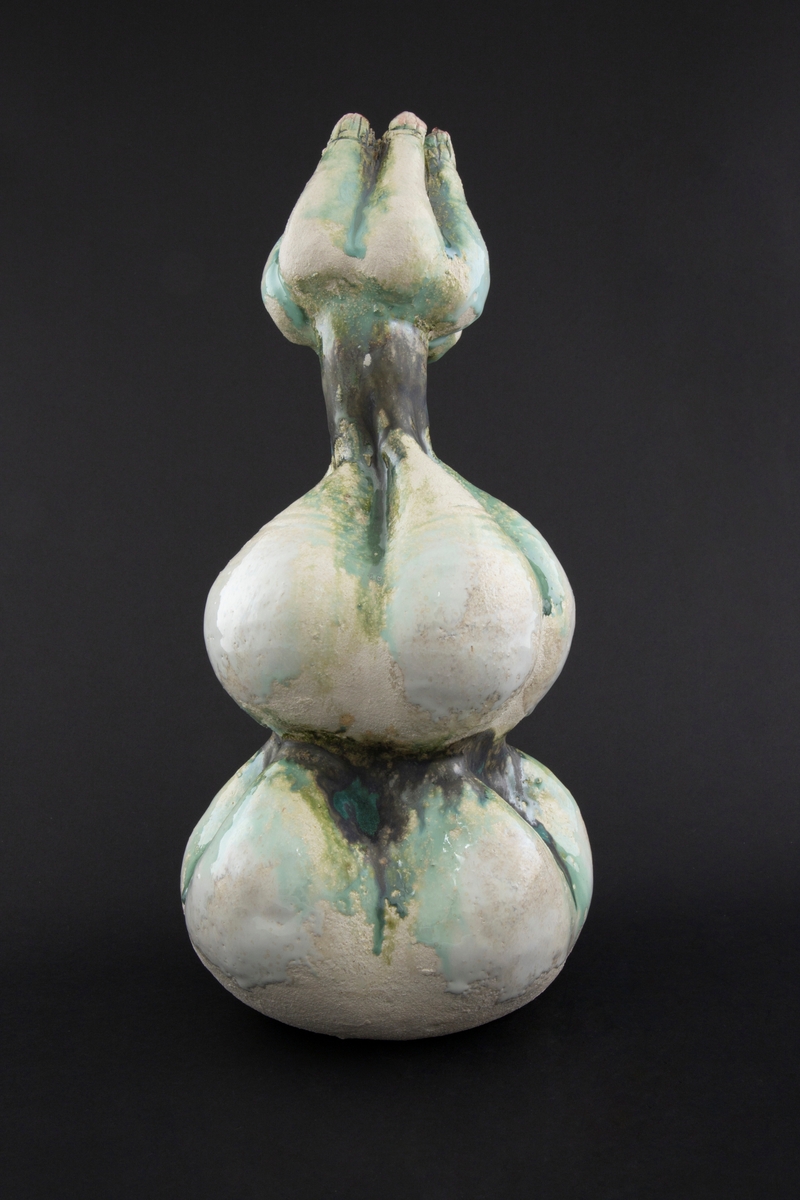 Håndmodellert skulptur i glasert steingods med oppreist holdning. Den har en organisk og asymmetrisk kalebassform som ender i en tulipanform med halvåpne kronblader. Keramikkskulpturen inngår i en installasjon bestående av 26 deler i ulike størrelser og med individuell utforming. De asymmetriske variasjonene gir et inntrykk av bevegelse, og den lett sykelige fargepaletten gir et uhyggelig og grotesk preg. Samtlige deler minner om kjøttetende planter.