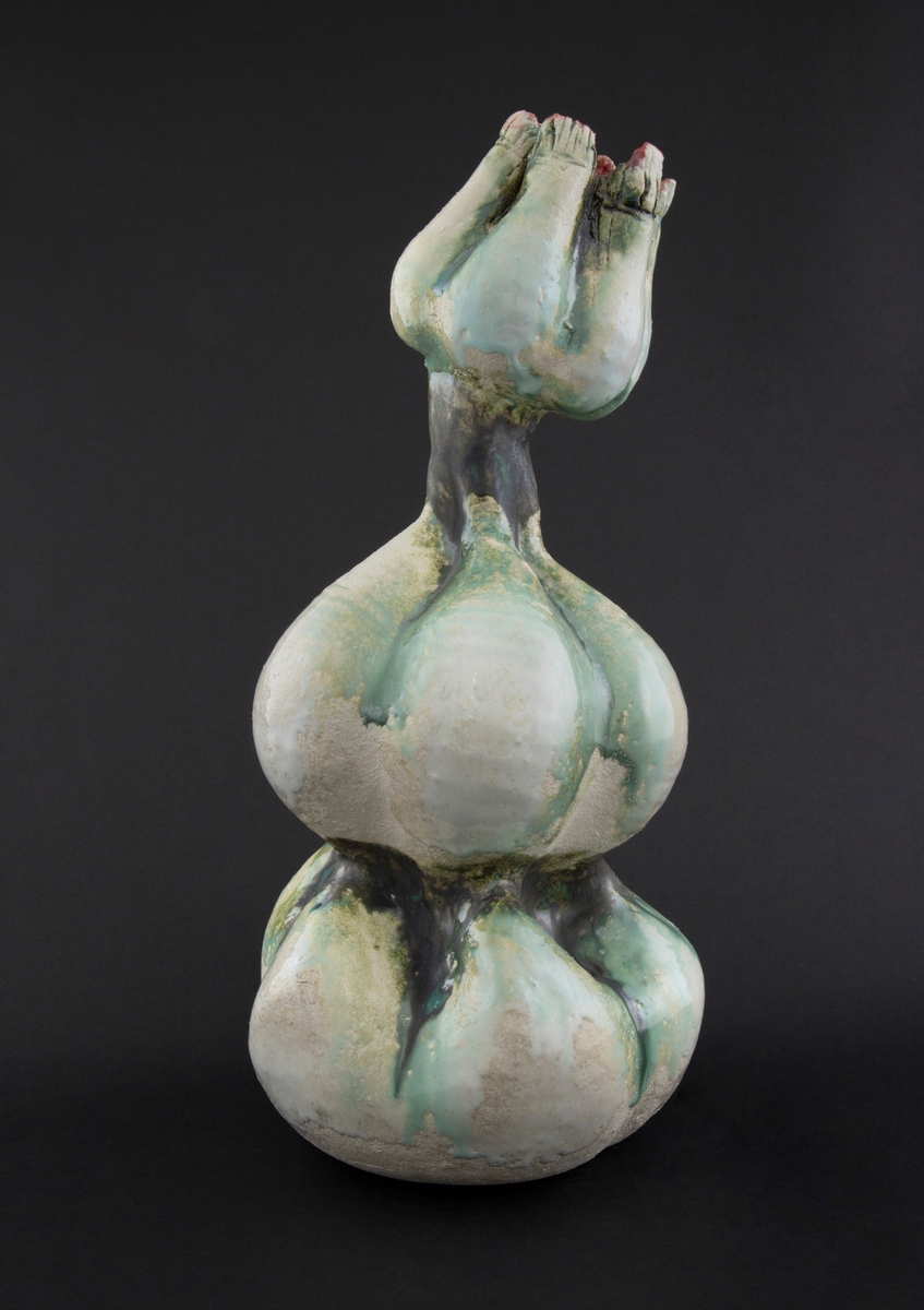 Håndmodellert skulptur i glasert steingods med oppreist holdning. Den har en organisk og asymmetrisk kalebassform som ender i en tulipanform med halvåpne kronblader. Keramikkskulpturen inngår i en installasjon bestående av 26 deler i ulike størrelser og med individuell utforming. De asymmetriske variasjonene gir et inntrykk av bevegelse, og den lett sykelige fargepaletten gir et uhyggelig og grotesk preg. Samtlige deler minner om kjøttetende planter.