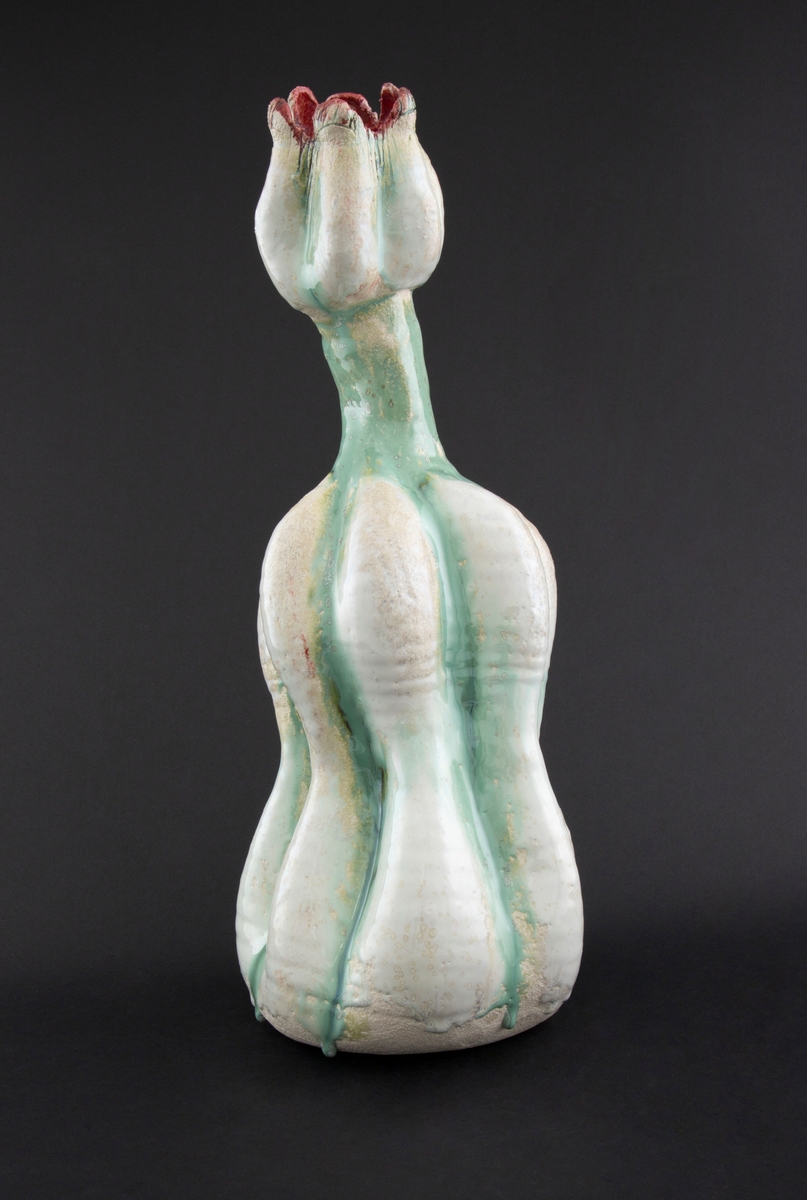 Håndmodellert skulptur i glasert steingods med oppreist holdning. Den har en organisk og asymmetrisk kalebassform som ender i en tulipanform med halvåpne kronblader. Keramikkskulpturen inngår i en installasjon bestående av 26 deler i ulike størrelser og med individuell utforming. De asymmetriske variasjonene gir et inntrykk av bevegelse, og den lett sykelige fargepaletten gir et uhyggelig og grotesk preg. Samtlige deler minner om kjøttetende planter.