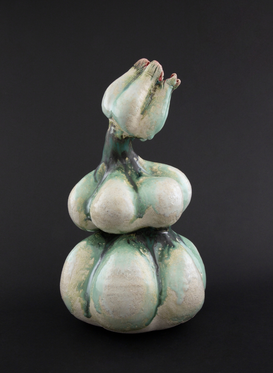 Håndmodellert skulptur i glasert steingods med lett tiltende hode. Den har en organisk og asymmetrisk kalebassform som ender i en tulipanform med halvåpne kronblader. Keramikkskulpturen inngår i en installasjon bestående av 26 deler i ulike størrelser og med individuell utforming. De asymmetriske variasjonene gir et inntrykk av bevegelse, og den lett sykelige fargepaletten gir et uhyggelig og grotesk preg. Samtlige deler minner om kjøttetende planter.