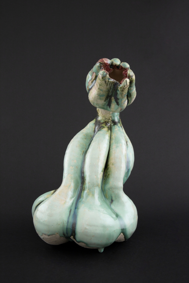 Håndmodellert skulptur i glasert steingods med S-formet kropp. Den har en organisk og asymmetrisk kalebassform som ender i en tulipanform med halvåpne kronblader. Keramikkskulpturen inngår i en installasjon bestående av 26 deler i ulike størrelser og med individuell utforming. De asymmetriske variasjonene gir et inntrykk av bevegelse, og den lett sykelige fargepaletten gir et uhyggelig og grotesk preg. Samtlige deler minner om kjøttetende planter.