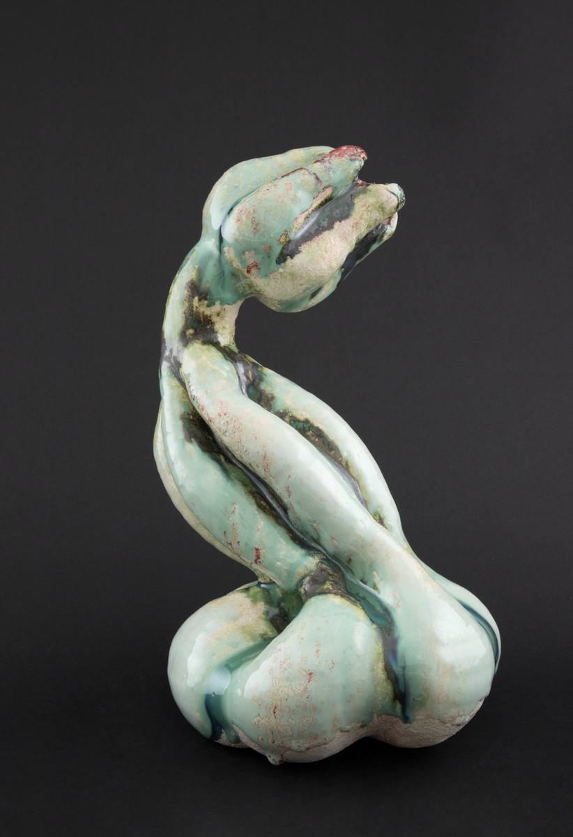 Håndmodellert skulptur i glasert steingods med S-formet kropp. Den har en organisk og asymmetrisk kalebassform som ender i en tulipanform med halvåpne kronblader. Keramikkskulpturen inngår i en installasjon bestående av 26 deler i ulike størrelser og med individuell utforming. De asymmetriske variasjonene gir et inntrykk av bevegelse, og den lett sykelige fargepaletten gir et uhyggelig og grotesk preg. Samtlige deler minner om kjøttetende planter.