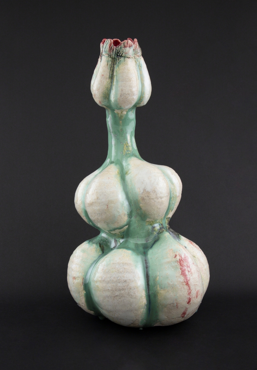 Håndmodellert skulptur i glasert steingods med litt svai kropp. Den har en organisk og asymmetrisk kalebassform som ender i en tulipanform med halvåpne kronblader. Keramikkskulpturen inngår i en installasjon bestående av 26 deler i ulike størrelser og med individuell utforming. De asymmetriske variasjonene gir et inntrykk av bevegelse, og den lett sykelige fargepaletten gir et uhyggelig og grotesk preg. Samtlige deler minner om kjøttetende planter.