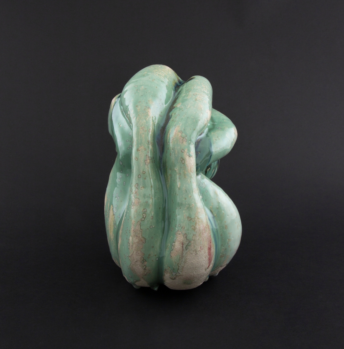 Håndmodellert skulptur i glasert steingods i liggende positur. Den har en organisk og asymmetrisk kalebassform som ender i en tulipanform med halvåpne kronblader. Keramikkskulpturen inngår i en installasjon bestående av 26 deler i ulike størrelser og med individuell utforming. De asymmetriske variasjonene gir et inntrykk av bevegelse, og den lett sykelige fargepaletten gir et uhyggelig og grotesk preg. Samtlige deler minner om kjøttetende planter.