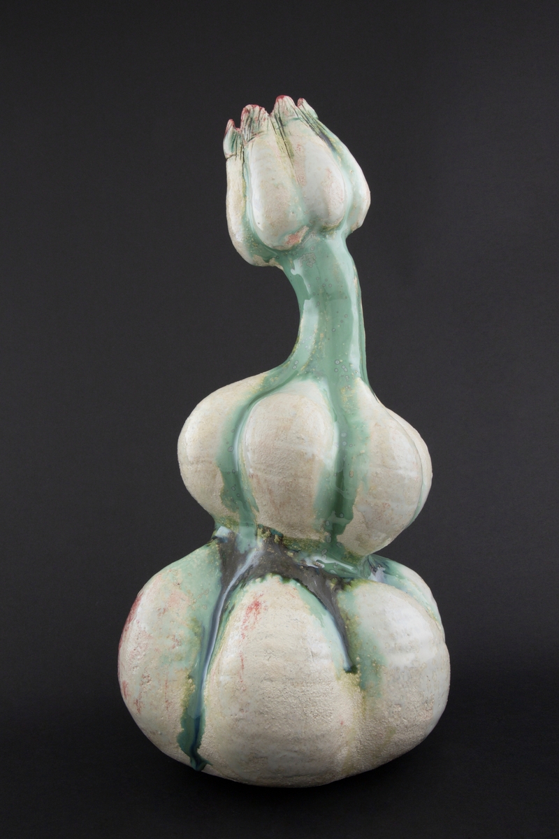 Håndmodellert skulptur i glasert steingods med litt svai kropp. Den har en organisk og asymmetrisk kalebassform som ender i en tulipanform med halvåpne kronblader. Keramikkskulpturen inngår i en installasjon bestående av 26 deler i ulike størrelser og med individuell utforming. De asymmetriske variasjonene gir et inntrykk av bevegelse, og den lett sykelige fargepaletten gir et uhyggelig og grotesk preg. Samtlige deler minner om kjøttetende planter.