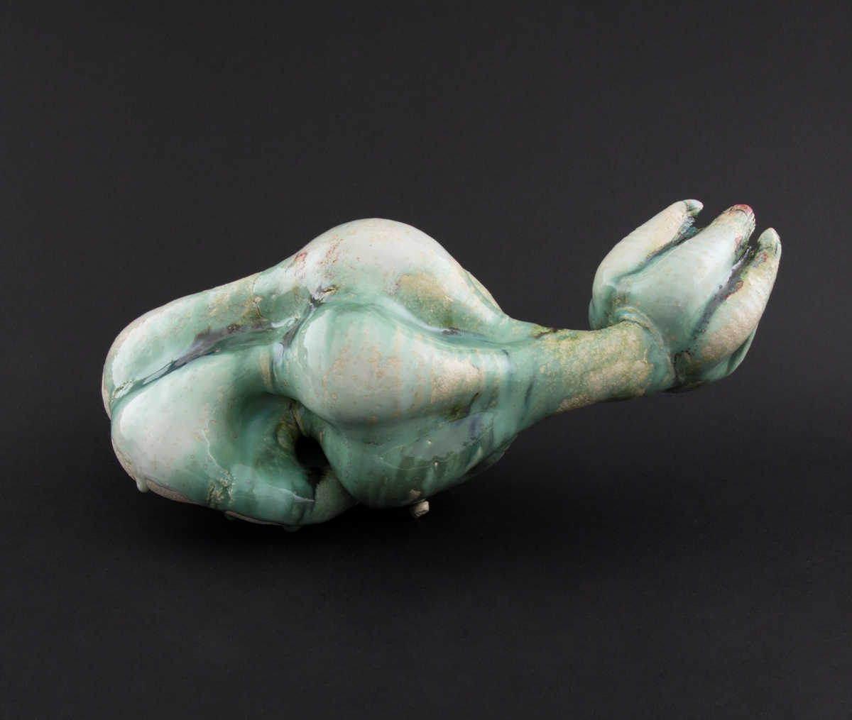 Håndmodellert skulptur i glasert steingods i nesten liggende positur. Den har en organisk og asymmetrisk kalebassform som ender i en tulipanform med halvåpne kronblader. Keramikkskulpturen inngår i en installasjon bestående av 26 deler i ulike størrelser og med individuell utforming. De asymmetriske variasjonene gir et inntrykk av bevegelse, og den lett sykelige fargepaletten gir et uhyggelig og grotesk preg. Samtlige deler minner om kjøttetende planter.