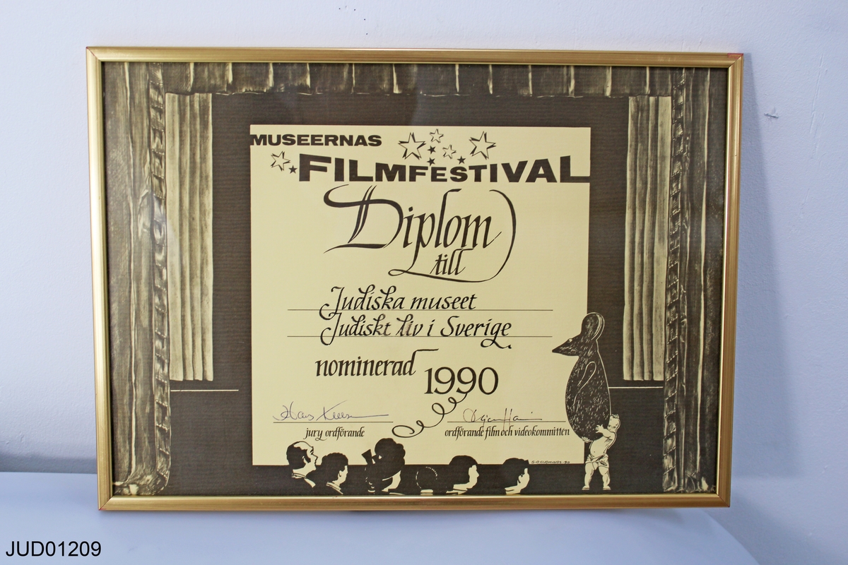 Inramat diplom till Judiska museet och filmen "Judiskt liv i Sverige", som nominerats vid museernas filmfestival 1990. Signerad av juryns ordförande och ordförande i film- och videokommittén.