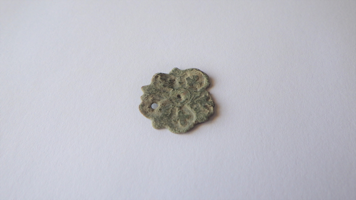 MALV: DIAM. 19 MM, 5-BLADET ROSETT MED LIKARMET KORS I HVERT BLAD. NOE FRAGMENTARISK. 
