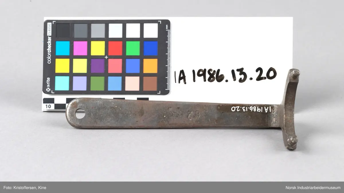 Akselmutternøkkel med 39 mm åpning. Avrundt skaft med hull i enden. Hode er bøyd og har en u-formet bøy i åpningen og to mintre tagger som stikker opp på hver side
