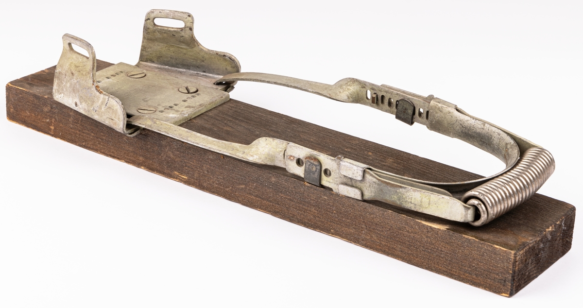Acc.kat: Skidbindningsprov. Vit metallegering på mörkbrunfärgat trä. Metallremmar. Märken i metallen "KVICK MADE IN SWEDEN MIÖENS PATENT PAT. APPL. FOR."