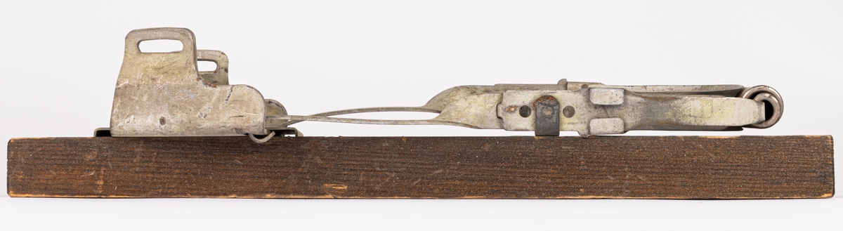 Acc.kat: Skidbindningsprov. Vit metallegering på mörkbrunfärgat trä. Metallremmar. Märken i metallen "KVICK MADE IN SWEDEN MIÖENS PATENT PAT. APPL. FOR."