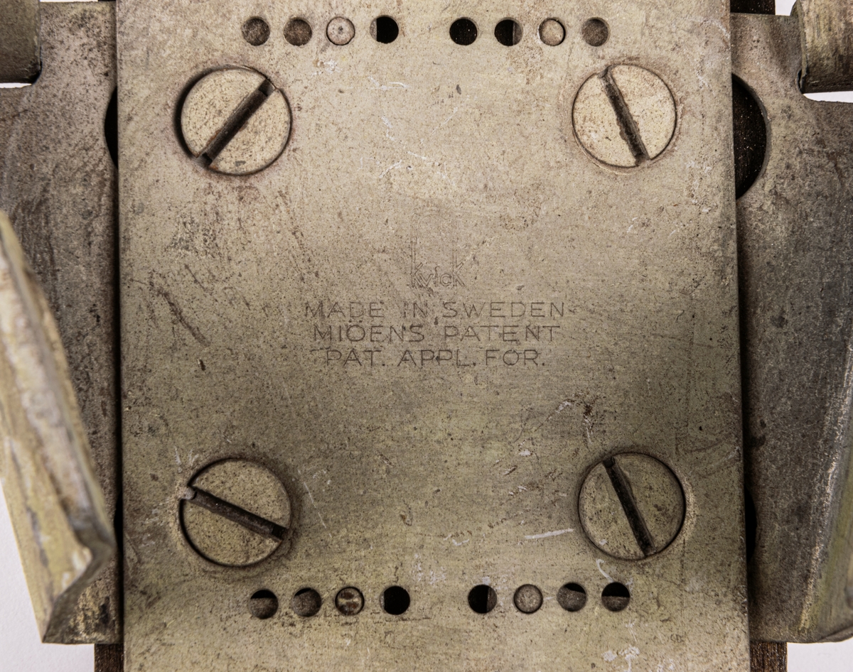 Acc.kat: Skidbindningsprov. Vit metallegering på mörkbrunfärgat trä. Metallremmar. Märken i metallen "KVICK MADE IN SWEDEN MIÖENS PATENT PAT. APPL. FOR."