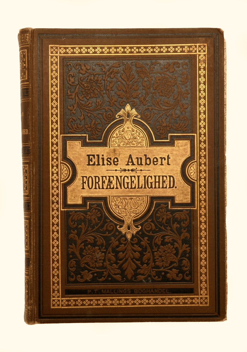 Boken "Forfængelighed" av Elise Aubert. Boken er på 297 sider uten avsnitt/kapitler. Det er heller ingen illustrasjoner i boken. Boken har stive permer trukket med brunt overtrekkspapir. På forsiden er det svarte striper som rammer inn forsiden med en bord med gullkors innenfor. Innenfor er det brune blomsterranker på svart bunn. På midten er det et gullfelt med forfatternavn og tittel. På ryggen er det fire felter med gulldekor og et felt med forfatter og tittel. På innsiden av perm og første (og siste) blad har trykt blomstermotiv. På neste blad er det skrevet med penn, se "Påført tekst/merker". For mer informasjon om boken se foto av tittelbladet.