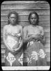 Bilden visar två flickor på Tahiti med traditionella kläder. Enligt Etnografiska Museets bildinformation är det Moea, 18 år och Fatiamai, 15 år från Te Höro, Idaididi.