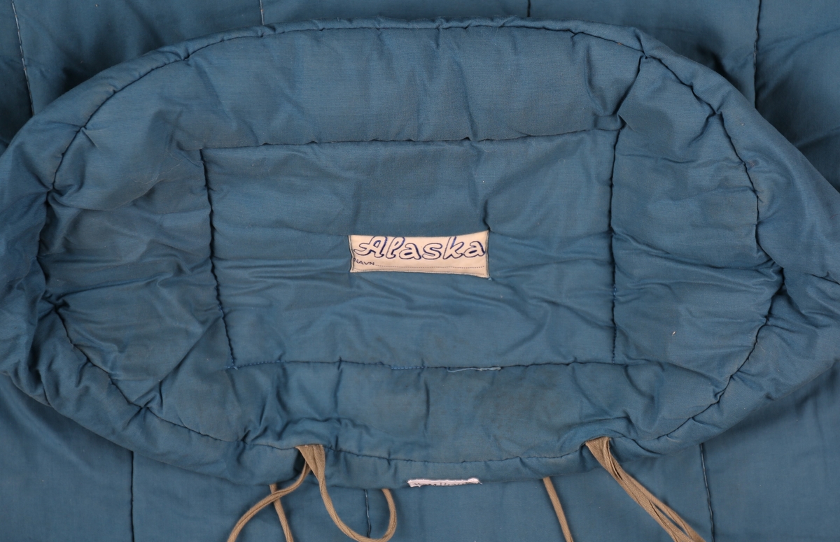 Avlang sovepose for turbruk. Glidelås i front med trekanta stoppar i kunstlær i enden. Klaff på innsida under glidelås. Posen er avrunda i begge ender. Vattert med langsgåande saumar gjennom trekk og vatt. Rund opning for hovud/hals oppom glidelåsen. To knyteband i fotenden.