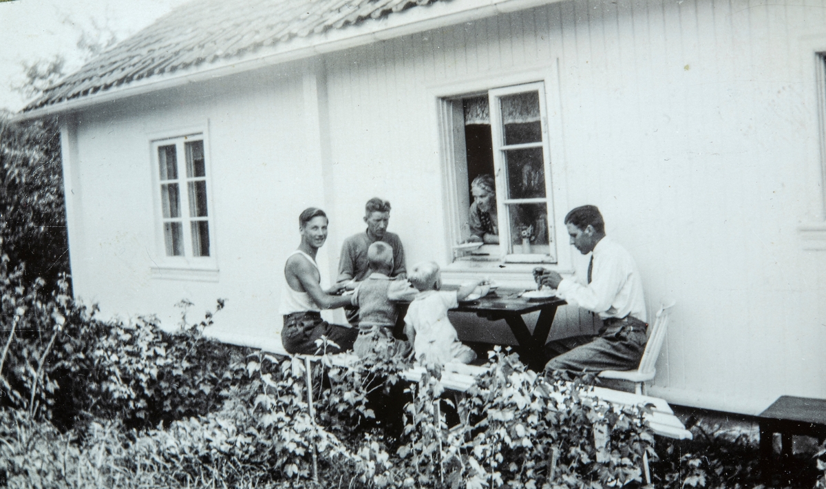 Spisepause ved Vestre Gulkunrud i Ottestad. Sittende fra venstre: Johan Knudsen, Birger Lindewall, Knud Knudsen, Oskar Knudsen, Nils Lindewall. I vinduet Mariane Lindewall.