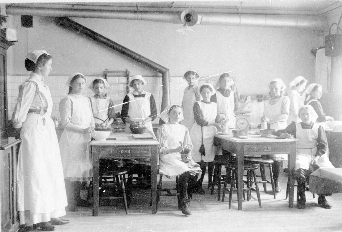 Alingsås första skolkök, på Centralskolan.

Från vänster: Fröken Broman. Hilma Olander. Hilda Bergstrand. Alice Brask. Edith Sandin. Rut Dalgren. Greta Skarin. Svea Klinge. Anna Hasselskog. Edit Edholm.

Sittande från vänster: Dagny Sjöström. Ida Johansson.