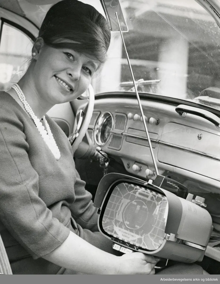 Eva Torp med et Sony reise-tv i sin Volkswagen boble. Oktober 1962.