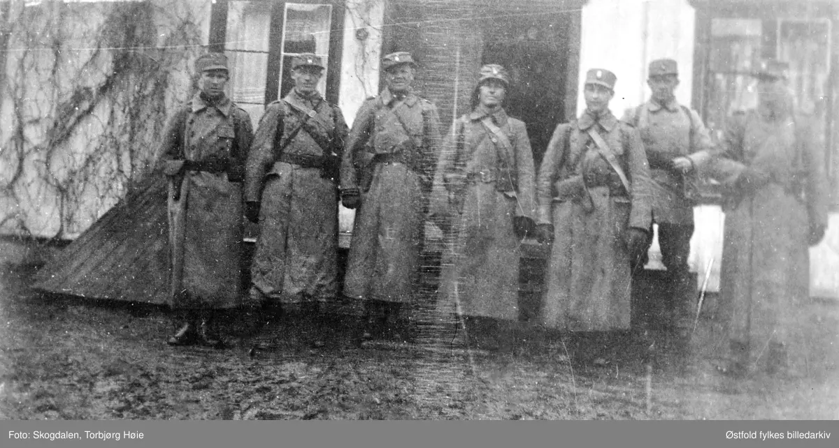 Fra gården Salmonrud i Eidsberg i april 1940, kaptein Rolf  Graffs batteri under tilbaketrekning fra Fossum. Sju soldater i uniform står foran våningshuset.