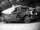 En buss av märket General Motors Coach, möjligen årsmodell 1931 med registreringsnummer F703.  På sidan märkt 