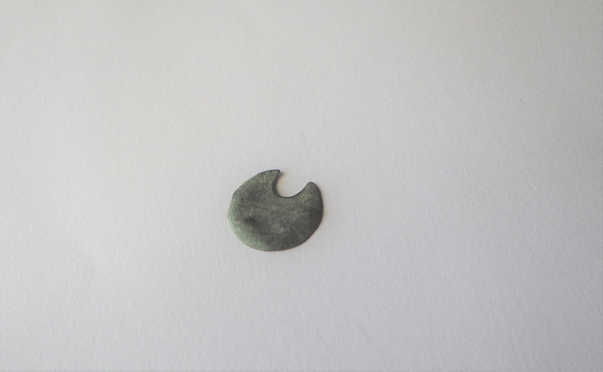 MALV: DIAM. 13, 1 MM, RUND FLAT UTEN DEKOR. ØDELAGT VED HULLET. 
