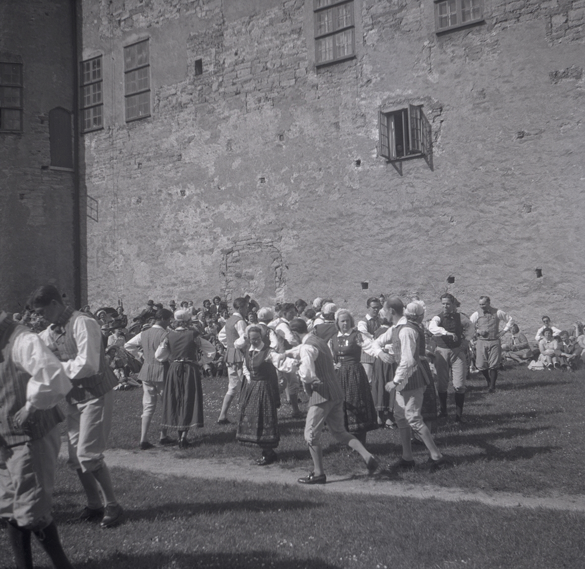 En orkester som spelar violin och folk som dansar i folkdräkter på Kalmar slott.