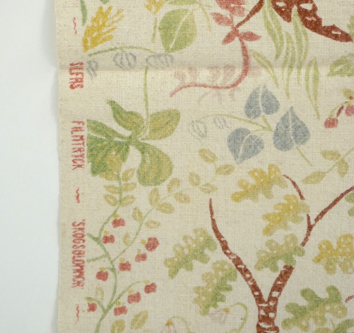 Tygstycke med trycket "Skogsblomma" från SILFA. Sydd kanal i ena änden.