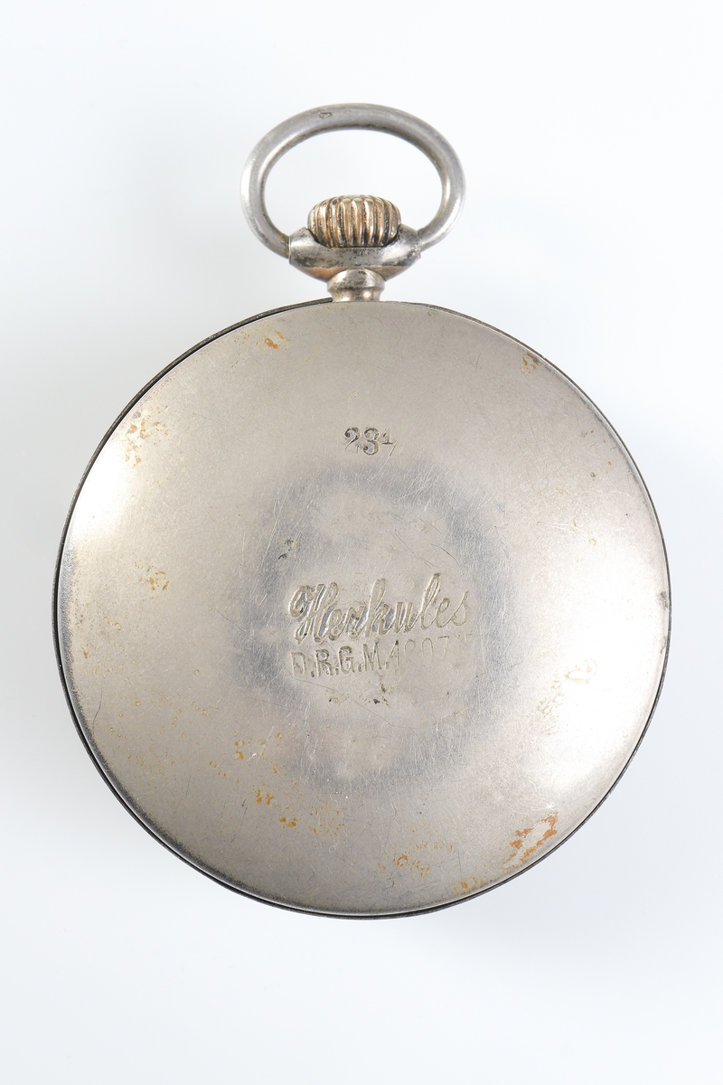 Fickur i silver som dras upp med krona. Runt kronan finns en bygel för att fästa en klockkedja. Den främre boetten har ett glas monterat framför urtavlan som består av vit emalj. Visarna är utsirade i guldfärg, och nedtill en mindre urtavla för sekundvisning. Bakboetten har ett mönstrat motiv liknande det svenska riksvapnet med två lejon på vardera sidan om en sköld krönt med en krona. Boettens ytterkanter är guldförgyllda. Ytterboettens insida har en stämpel liknande en halvmåne och en kungakrona, samt en större och en mindre som liknar en orre. Vidare finns numret "304070" och "0.800" inramat. Även "GALONNE" finns stämplat och siffran "11". Innerboettens utsida har ett graverat mönster bestående av ett liggande lejon med en sköld med de tre svenska kronorna vid sidan om. Vidare finns texten "1/2 CHRONOMETRE REMONTOIR SPIRAL BREGUET" och "CHATON OR 19 RUBIS" samt "BALANCIER COMPENSSÉ". Innerboettens insida har numret "304070" och stämpeln liknande halvmåne och krona inslaget, samt "0.800" inramat. Verket utan stämplar. 
Klockans skyddsboett i två delar, består av en överdel med ett fönster i celluloid, och en underdel att lägga uret i. Baksidan märkt med "23 1/2" och "Herkules D.R.G.M. 160717". Dosan troligen i nickel.