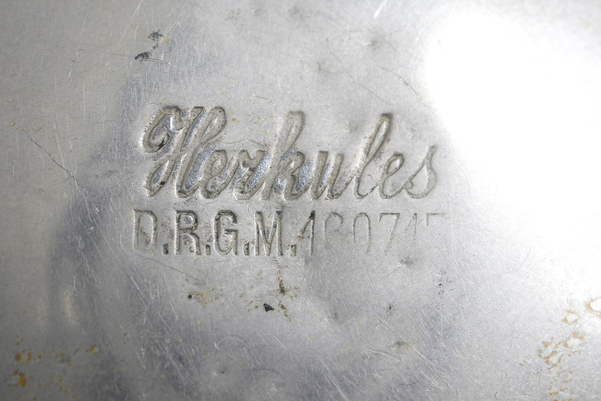 Fickur i silver som dras upp med krona. Runt kronan finns en bygel för att fästa en klockkedja. Den främre boetten har ett glas monterat framför urtavlan som består av vit emalj. Visarna är utsirade i guldfärg, och nedtill en mindre urtavla för sekundvisning. Bakboetten har ett mönstrat motiv liknande det svenska riksvapnet med två lejon på vardera sidan om en sköld krönt med en krona. Boettens ytterkanter är guldförgyllda. Ytterboettens insida har en stämpel liknande en halvmåne och en kungakrona, samt en större och en mindre som liknar en orre. Vidare finns numret "304070" och "0.800" inramat. Även "GALONNE" finns stämplat och siffran "11". Innerboettens utsida har ett graverat mönster bestående av ett liggande lejon med en sköld med de tre svenska kronorna vid sidan om. Vidare finns texten "1/2 CHRONOMETRE REMONTOIR SPIRAL BREGUET" och "CHATON OR 19 RUBIS" samt "BALANCIER COMPENSSÉ". Innerboettens insida har numret "304070" och stämpeln liknande halvmåne och krona inslaget, samt "0.800" inramat. Verket utan stämplar. 
Klockans skyddsboett i två delar, består av en överdel med ett fönster i celluloid, och en underdel att lägga uret i. Baksidan märkt med "23 1/2" och "Herkules D.R.G.M. 160717". Dosan troligen i nickel.
