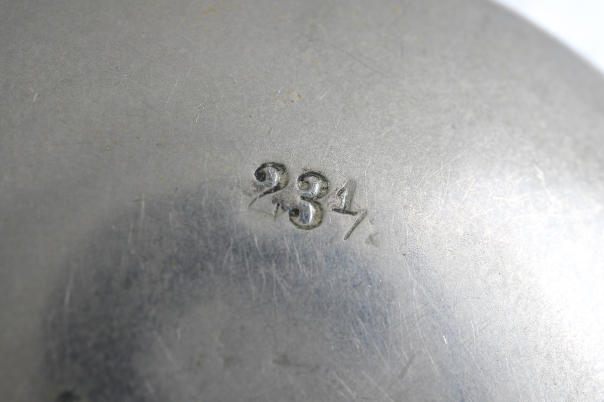 Fickur i silver som dras upp med krona. Runt kronan finns en bygel för att fästa en klockkedja. Den främre boetten har ett glas monterat framför urtavlan som består av vit emalj. Visarna är utsirade i guldfärg, och nedtill en mindre urtavla för sekundvisning. Bakboetten har ett mönstrat motiv liknande det svenska riksvapnet med två lejon på vardera sidan om en sköld krönt med en krona. Boettens ytterkanter är guldförgyllda. Ytterboettens insida har en stämpel liknande en halvmåne och en kungakrona, samt en större och en mindre som liknar en orre. Vidare finns numret "304070" och "0.800" inramat. Även "GALONNE" finns stämplat och siffran "11". Innerboettens utsida har ett graverat mönster bestående av ett liggande lejon med en sköld med de tre svenska kronorna vid sidan om. Vidare finns texten "1/2 CHRONOMETRE REMONTOIR SPIRAL BREGUET" och "CHATON OR 19 RUBIS" samt "BALANCIER COMPENSSÉ". Innerboettens insida har numret "304070" och stämpeln liknande halvmåne och krona inslaget, samt "0.800" inramat. Verket utan stämplar. 
Klockans skyddsboett i två delar, består av en överdel med ett fönster i celluloid, och en underdel att lägga uret i. Baksidan märkt med "23 1/2" och "Herkules D.R.G.M. 160717". Dosan troligen i nickel.