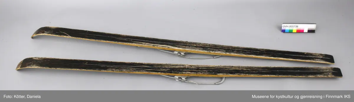 Treskiene er laget av et mørkt treslag i midten og et lyst treslag på kantene. Skiene er transparent lakkert. De har Kandahar - bindinger fra Gresvig som består av justerbare metalldeler og en fjærbånd som føres rund baksiden av skoen. Som skoens underlag er det spikret på grått kunststoff, eventuelt linoleum.  