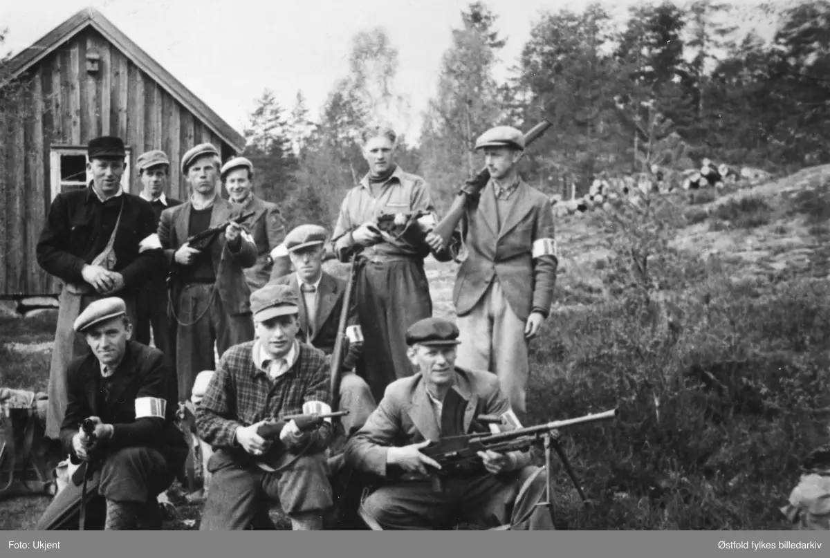 "Bondelaget" i hjemmestyrkene på Plommen, Jelsnes i Tune, like før "stormen" på formiddagen 9. mai 1945.
1. rekke fra venstre: Arne Berger, Kåre Braadland, Arnold Bjørnstad
2. rekke fra venstre: Arne Brevik Tune, NN, Torstein Rekustad, NNAsbjørn Agnalt, Øivind Hansen, Svein Simonsen.
Bildet finnes i to utgaver. I bilde nummer to er de to ukjente retusjert bort. 
To navn mangler.