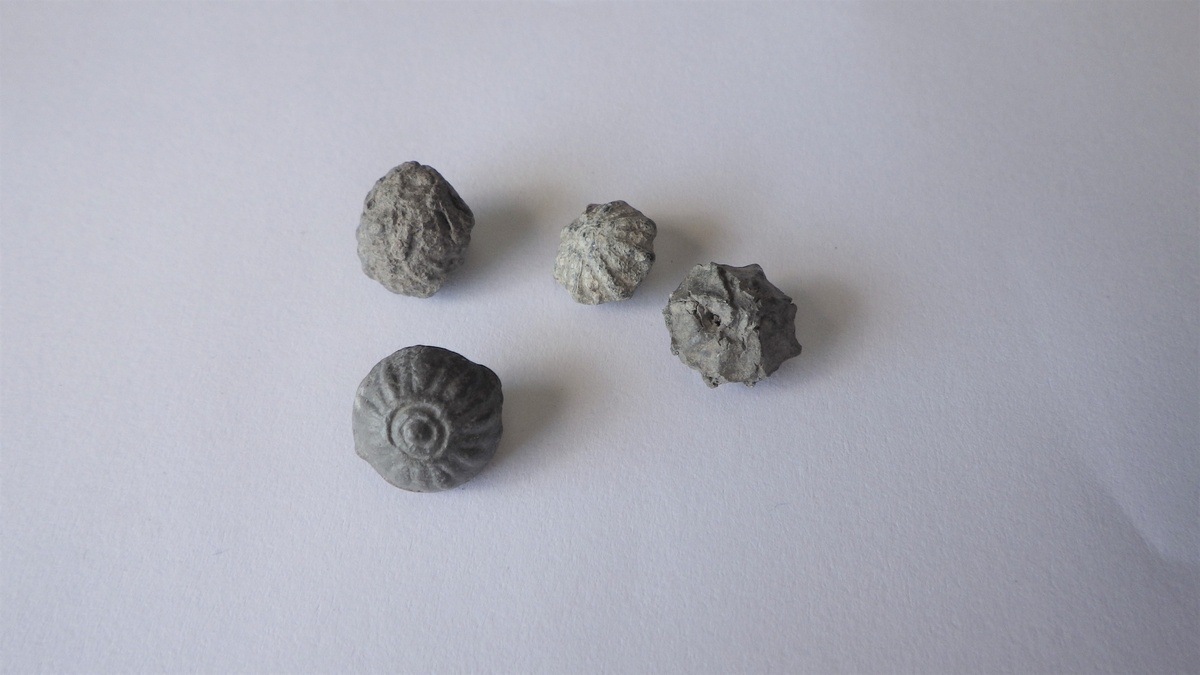 MALV: DIAM. 11 MM, EN MED DIAM. 10 MM, STØPT. DOBBELTKONISK. RESTER AV HEMPE. A: MANTELEN HAR RADIÆRE RIFTER, B: HAR RADIÆRE RIFTER PÅ MANTEL OGUNDERDEL. 