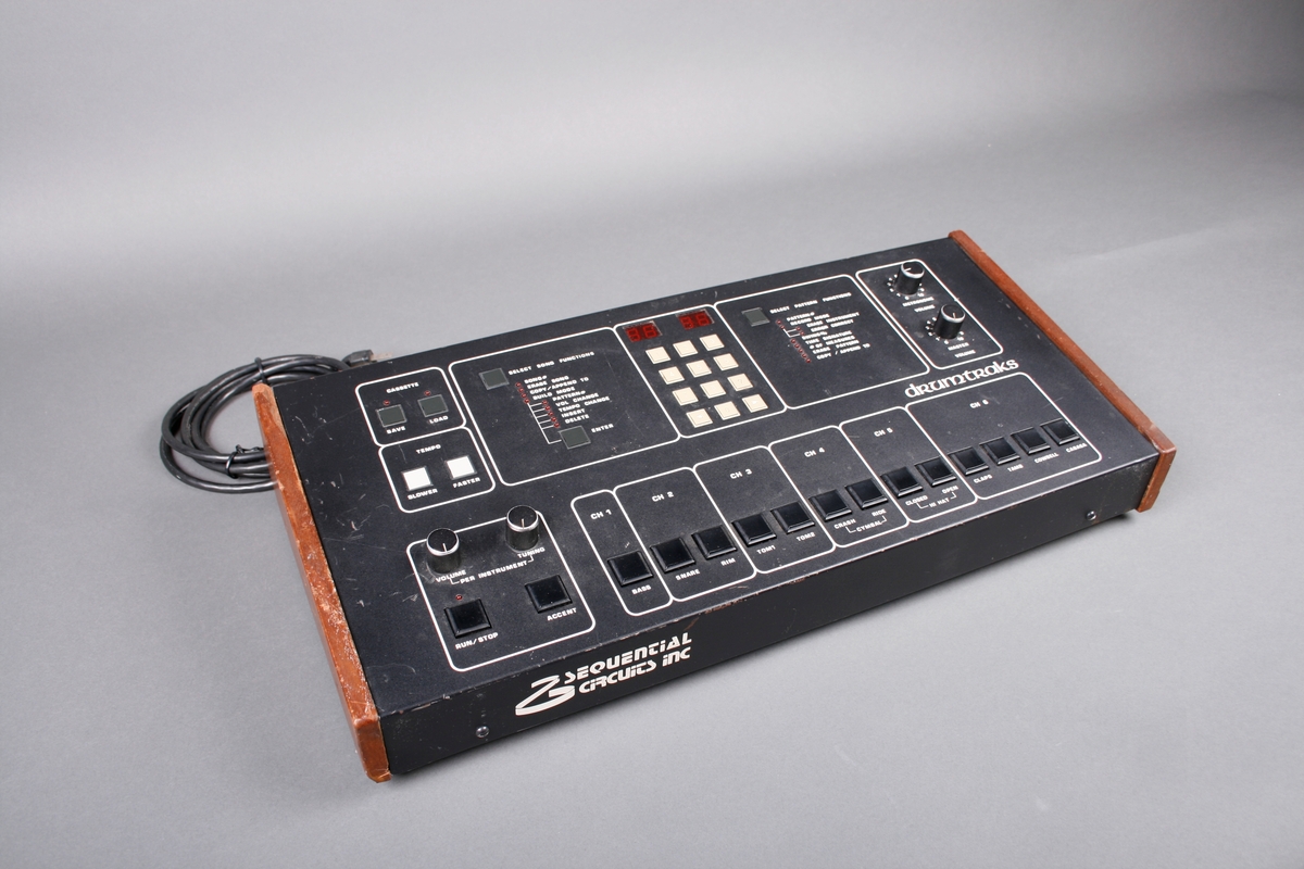 Elektronisk trommemaskin. Panel i kasse med kanter av treverk. Ledning og utganger på baksiden. Toppen av kassen er panel for innstillinger av trommelydene. Seks kanaler kan velges. Mange ulike funksjoner for opptak.
