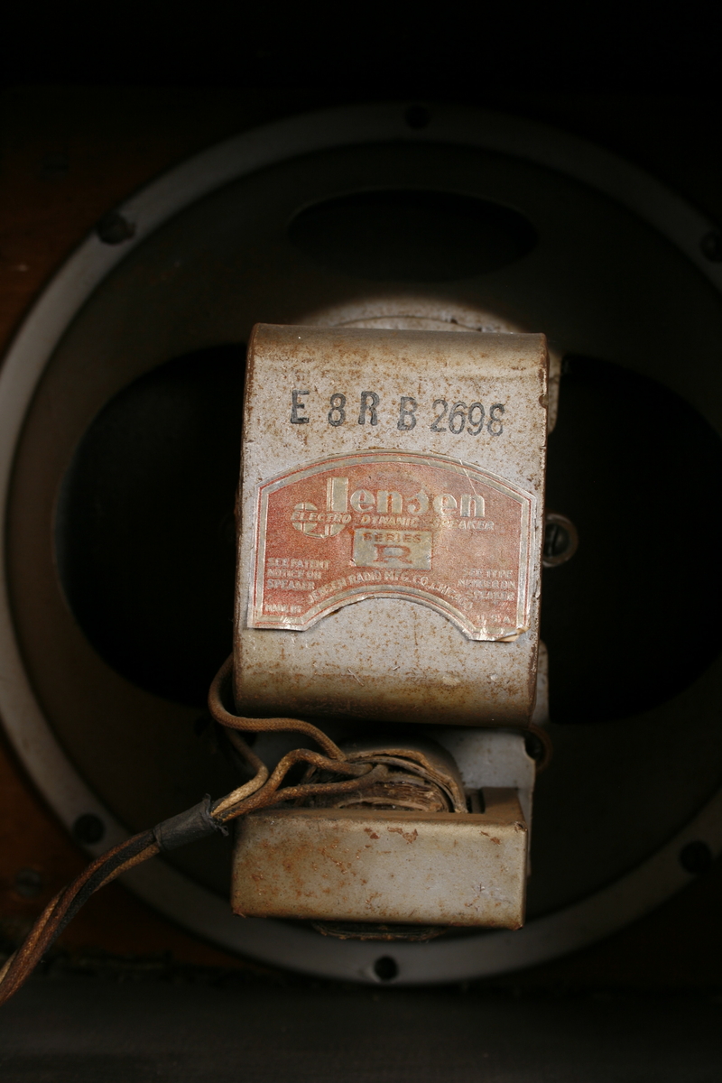 Radio i enkel kasse av finer. Rund høyttaler på venstre side av front. Skala med ramme i bakelitt på høyre side, under dette tre knapper i bakelitt: Volum, innstilling frekvens og av-på. Høyttaleren er omrammet av en ring i bakelitt og trukket med stoff.

Innvendig er apparatet delt i to, tilgang fra baksiden. På høyre side er høyttaleren og på venstre side radiorør og elektronikk med utgang for ledninger.