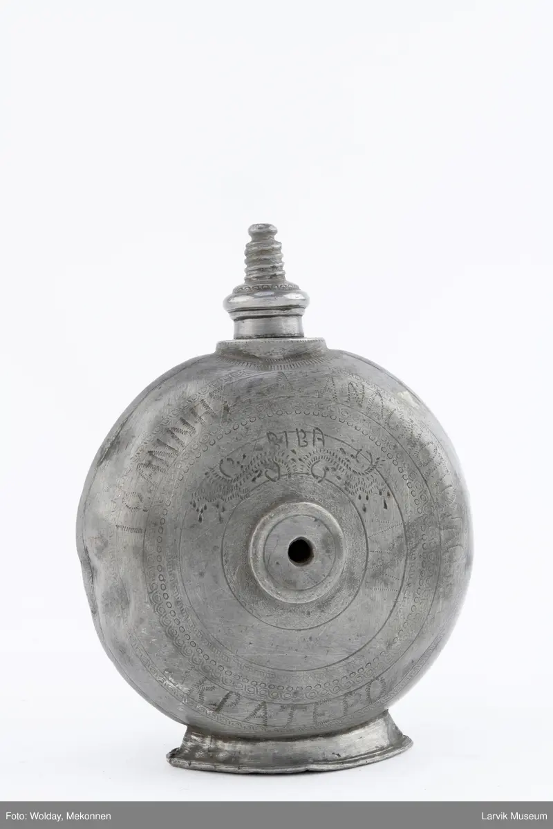 Påført bokstaver (greske?) og dekor og årstall 1930  på den ene siden og bokstaver (greske?), dektor og bokstavene BIBA på den andre siden