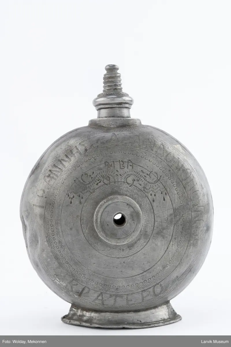 Påført bokstaver (greske?) og dekor og årstall 1930  på den ene siden og bokstaver (greske?), dektor og bokstavene BIBA på den andre siden