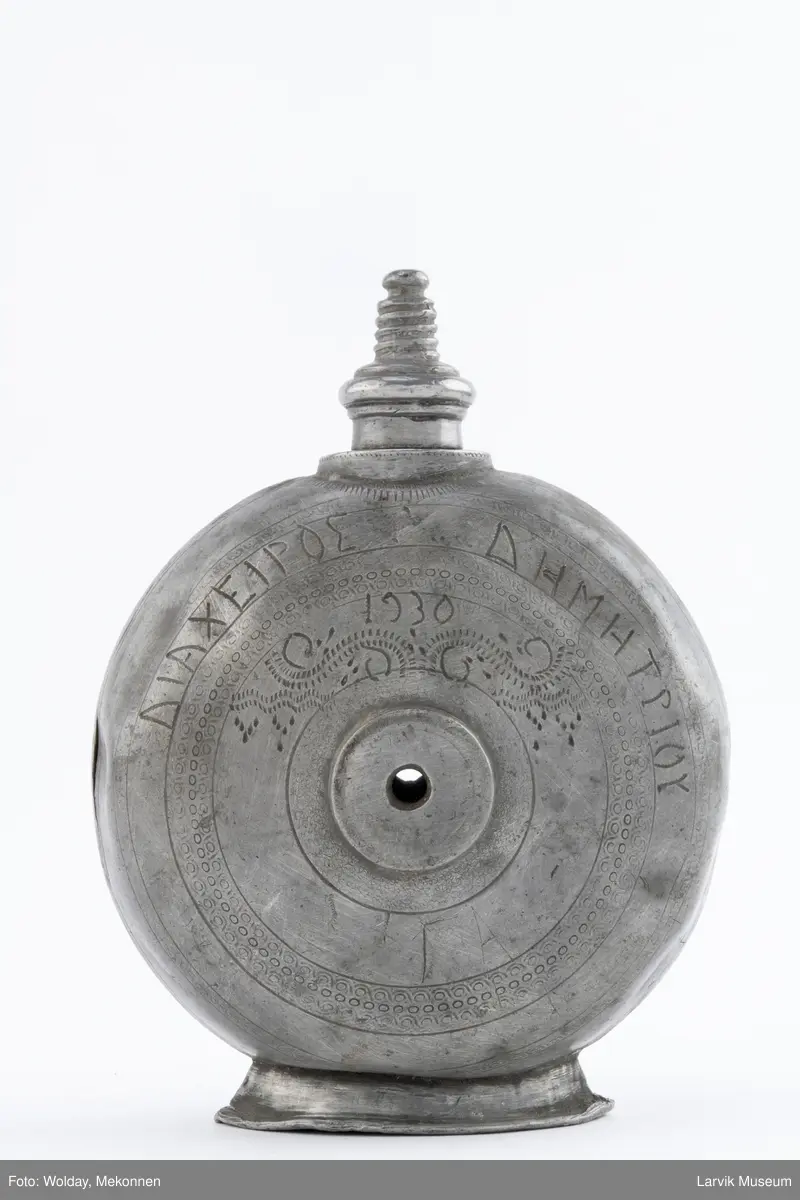 Påført bokstaver (greske?) og dekor og årstall 1930  på den ene siden og bokstaver (greske?), dektor og bokstavene BIBA på den andre siden