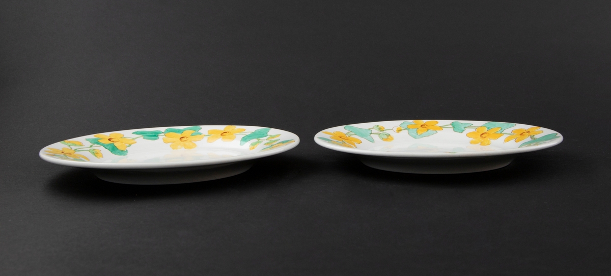 To asjetter i benhvitt flintgods. Dekorert langs kanten med konturtrykk av bekkeblomstmotiver i grønt og gult.