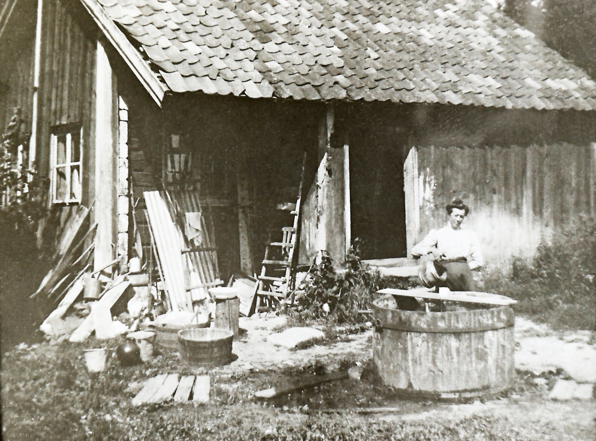 Julie Ljøterud (1876-1939) ved det gamle bryggerhuset som før har vært hovedygning, kalt Gamlestua. Den var opprinnelig et tilbygg til hovedbygningen (nå revet). I forgrunnen det gamle postkaret.