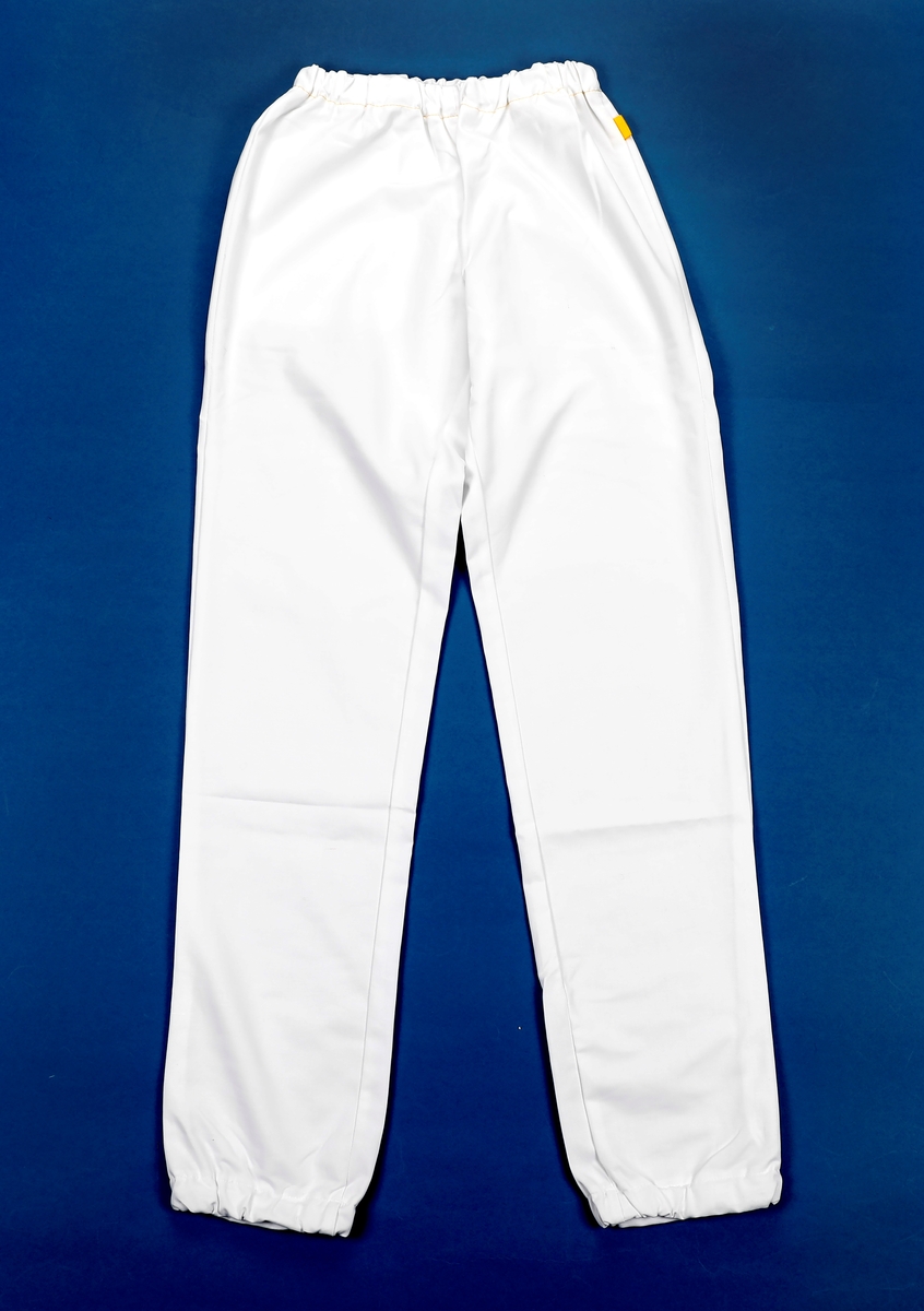 uniformsskjorte: kortermet med raglanermer. V-hals. Brystlomme og to lommer i hoftehøyde. 
uniformsbukse: strikk i livet og nederst på beina. En baklomme.
smittevernsfrakk:lang frakk med åpning bak. Knyting i nakken og ved et belte som er festet midt foran. Lange ermer med mansjetter av ribb som sitter etter. Sydd i et gult engangsmateriale.
hette: en stor sirkel som er rynket sammen med strikk rundt ytterkant. laget i et engangsmateriale
munnbind: rektangel med tre legg. bøybar bøyle over nesen som gjør at den kan ligge etter over nesen. Knyting på to punkter bak.
visir: Gjennomsiktig, rektangulært stykke i plast hvor det er festet skumgummi i overkant og strikk til å ha rundt hodet. avrundede hjørner i nedkant.
skotrekk: Engangstrekk i blå plast bestående av et rektangel med strikk rundt åpningen slik at den slutter om ankelen.
hansker: blå engangshansker med ruglete forsterkning på fingertuppene.