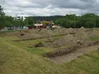 Sökschaktgrävning med grävmaskin i den södra delen av förundersökningsområdet vid Sandagymnasiet. I bakgrunden ses Engelska skolan.