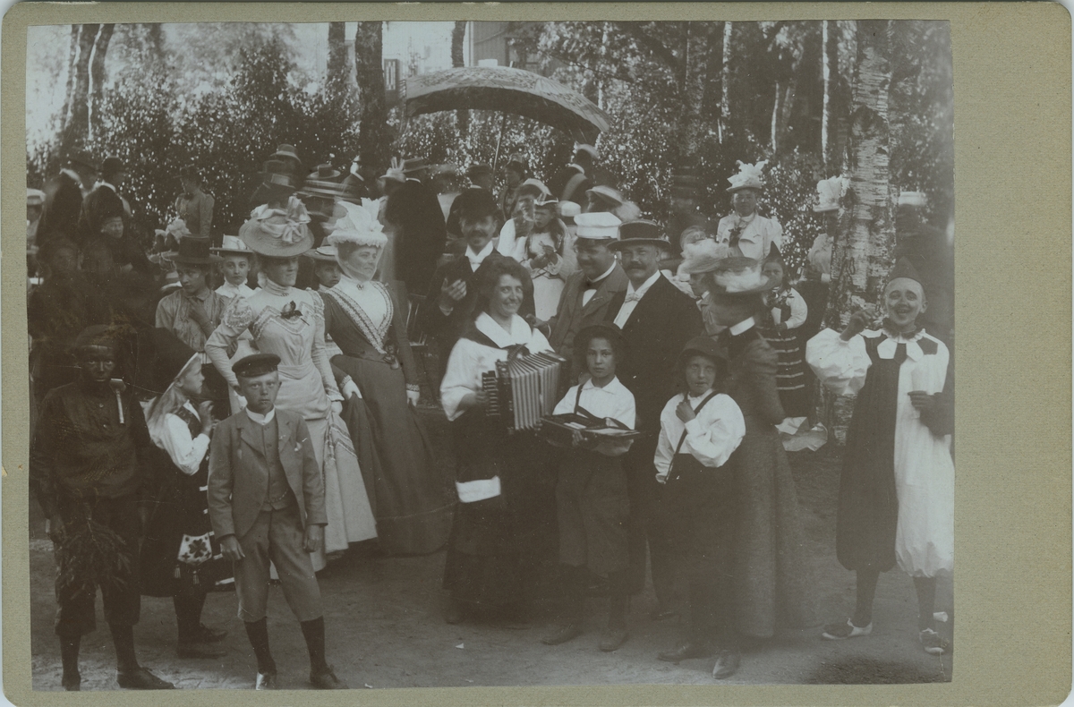 Text i guld på etuiets lock: MINNEN FRÅN GUSTAFSBERG 
Stämpel på baksidan fotogtafiet: "ROB. LINDAHL LYCKORNA LJUNGSKILE"
Handskriven text på baksidan fotografiet: "Bazar i Lyckorna 1901".

Detta brev fanns med i etuiet med Kabinettfoton.

Herr Dr. Kristiansson.

Vid genomgång av div. kuvert och portföljer fann jag dessa fotografier, som kanske kan vara av intresse för Museets porträtt-samling. PÅ baksidan av dem har min make identifierat en del av de avkonterfejade, som på den tiden vistades i Gustafsberg. Damernas klädedräkter med helt ansiktsflor och handskar, pojkarnas 2-hjulingar samt de unga herrarnas pampiga skägg borde kunna roa även nutida besökare. Dessutom en del fotos från Marstrand, Lysekil, Lyckorna samt några siluetter klippta i Gustafsberg.

Med vänlig hälsning Ebba Wittenström.

Måste få uttrycka min livliga förtjusning över den utomordentligt vackra och värdefulla tavelsamlingen i Museet. Skulle bara vilja sätta upp en ordentlig reklam-affisch i Hotellen för denna pärla i turistavseende.