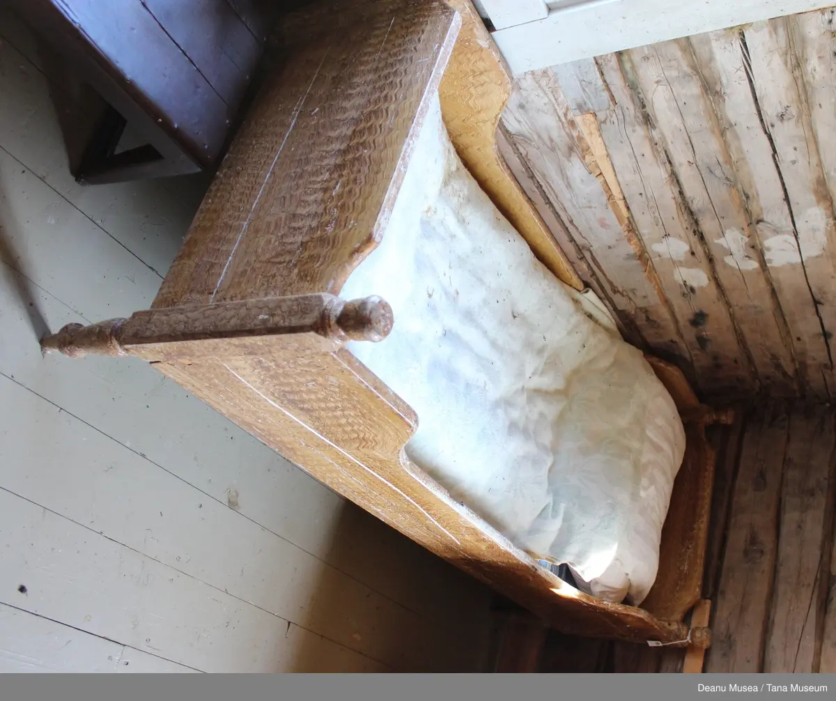 Seng i tre med enkel utskjæringer.