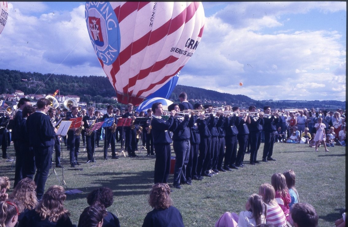 Vista High School Band från Californien spelar på en gräsplan framför en fylld luftballong med Jönköpings kommuns logo och texten "Gränna Sveriges Ballongcentrum".